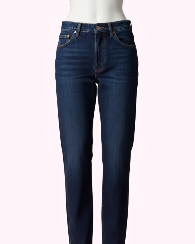 Mørkeblå denimbukser på mannequin med lyserød baggrund